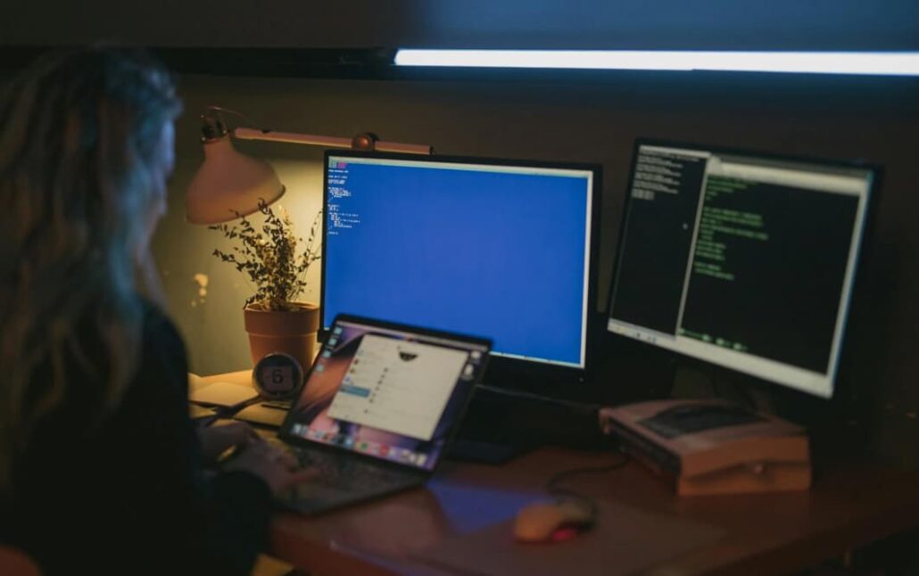 Person coding at a desk with monitors